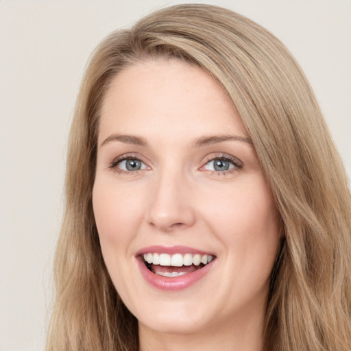 Joyful white young-adult female with long  brown hair and green eyes