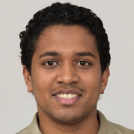 Joyful black young-adult male with short  black hair and brown eyes