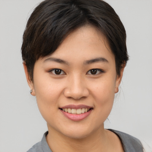 Joyful asian young-adult female with short  brown hair and brown eyes
