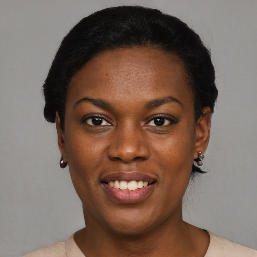 Joyful black young-adult female with short  black hair and brown eyes