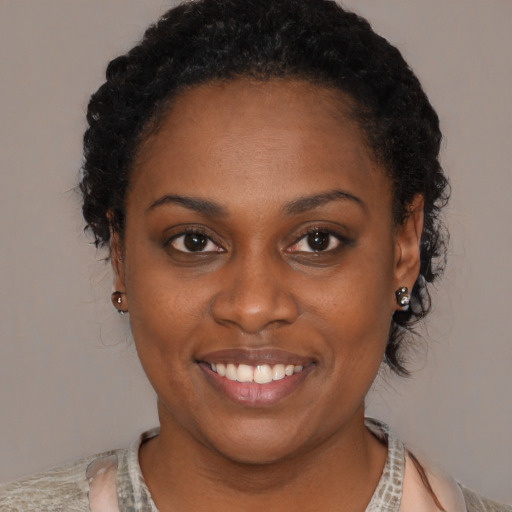 Joyful black young-adult female with medium  black hair and brown eyes