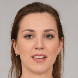 Joyful white young-adult female with long  brown hair and grey eyes