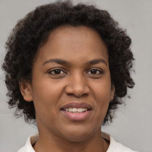 Joyful black young-adult female with short  brown hair and brown eyes