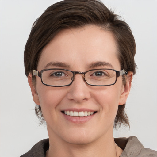 Joyful white young-adult female with medium  brown hair and grey eyes