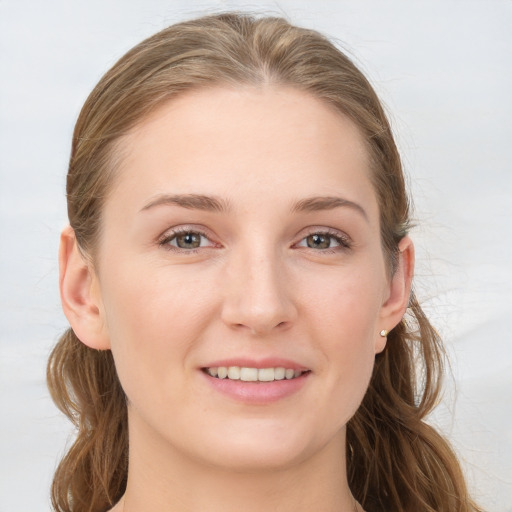 Joyful white young-adult female with long  brown hair and grey eyes