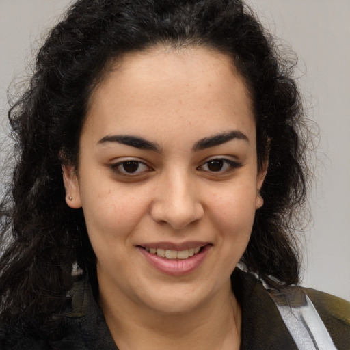 Joyful latino young-adult female with medium  brown hair and brown eyes