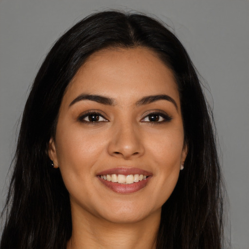 Joyful latino young-adult female with long  brown hair and brown eyes