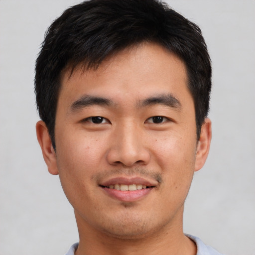 Joyful asian young-adult male with short  black hair and brown eyes
