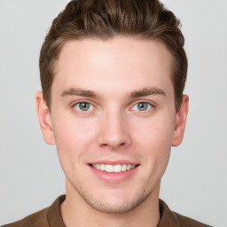 Joyful white young-adult male with short  brown hair and grey eyes