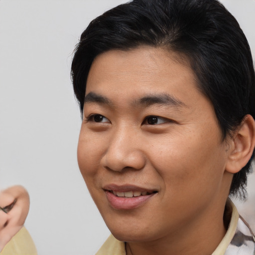 Joyful asian young-adult male with short  brown hair and brown eyes
