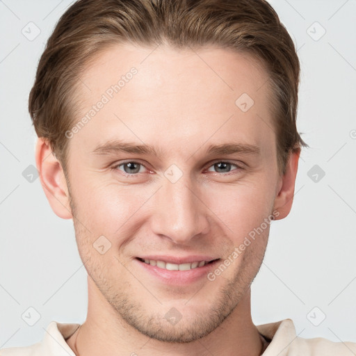 Joyful white young-adult male with short  brown hair and grey eyes