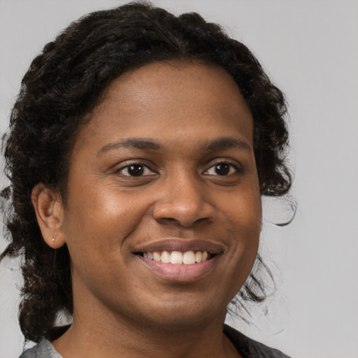 Joyful black young-adult female with medium  brown hair and brown eyes