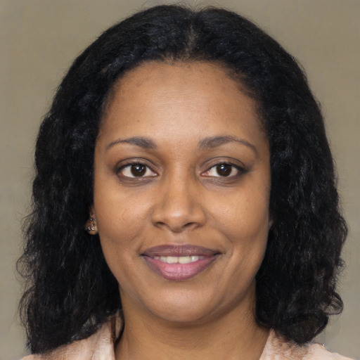 Joyful black adult female with long  black hair and brown eyes