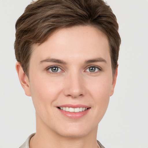 Joyful white young-adult female with short  brown hair and grey eyes