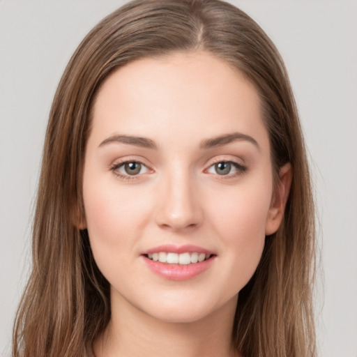 Joyful white young-adult female with long  brown hair and grey eyes