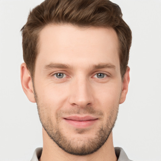 Joyful white young-adult male with short  brown hair and grey eyes