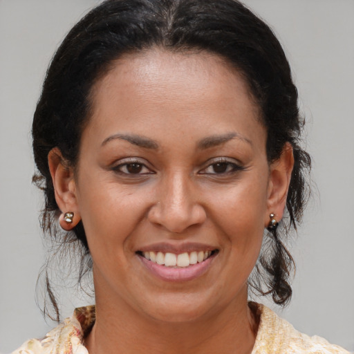 Joyful latino adult female with medium  brown hair and brown eyes