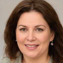 Joyful white adult female with medium  brown hair and green eyes