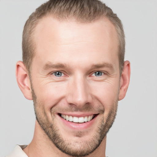 Joyful white young-adult male with short  brown hair and grey eyes