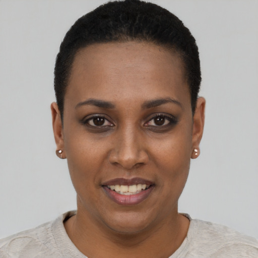 Joyful black young-adult female with short  black hair and brown eyes