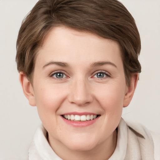 Joyful white young-adult female with short  brown hair and grey eyes