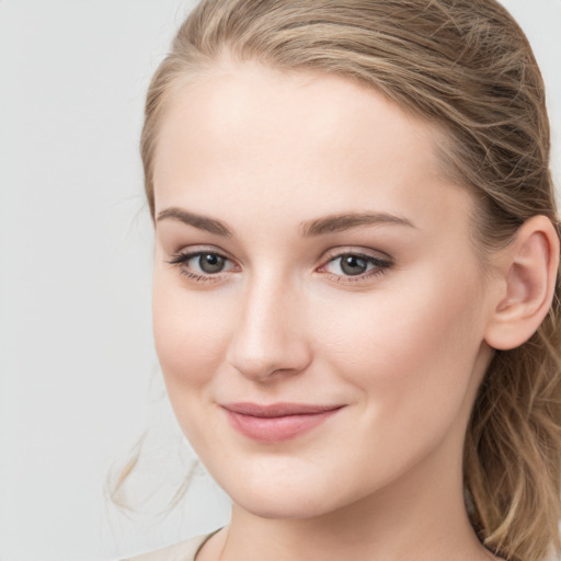 Joyful white young-adult female with long  brown hair and blue eyes