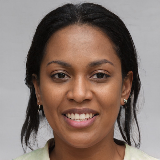 Joyful black young-adult female with medium  brown hair and brown eyes