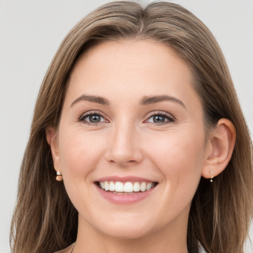 Joyful white young-adult female with long  brown hair and grey eyes