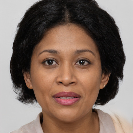 Joyful latino adult female with medium  brown hair and brown eyes