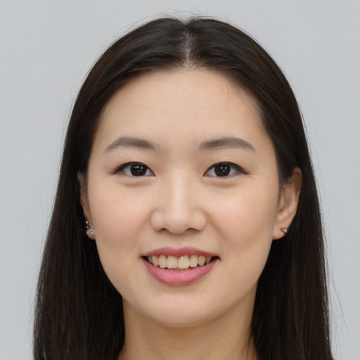 Joyful asian young-adult female with long  brown hair and brown eyes