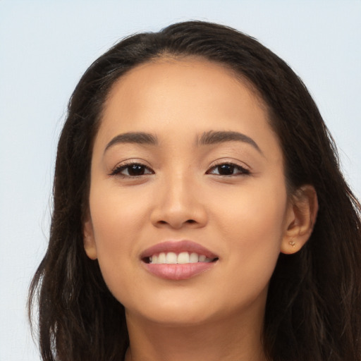 Joyful latino young-adult female with long  brown hair and brown eyes