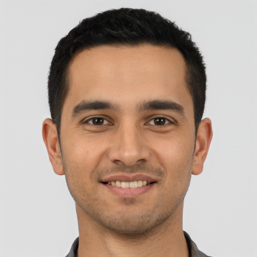 Joyful latino young-adult male with short  brown hair and brown eyes