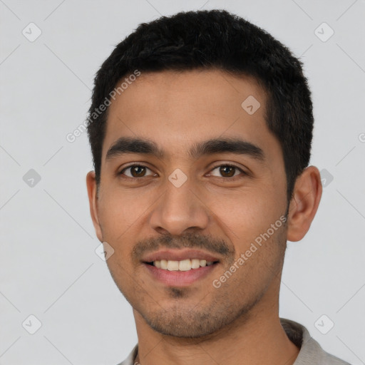 Joyful latino young-adult male with short  black hair and brown eyes