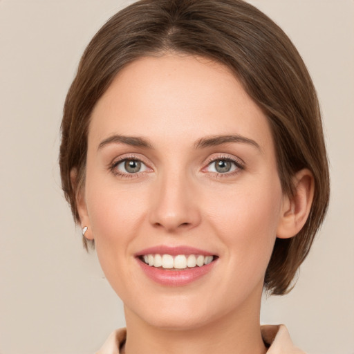 Joyful white young-adult female with medium  brown hair and green eyes