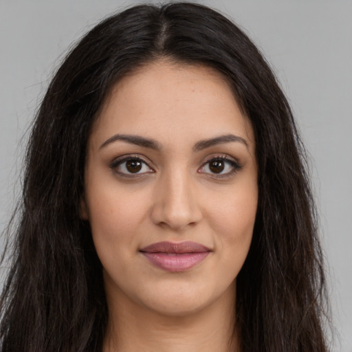 Joyful latino young-adult female with long  brown hair and brown eyes