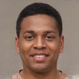 Joyful latino young-adult male with short  brown hair and brown eyes