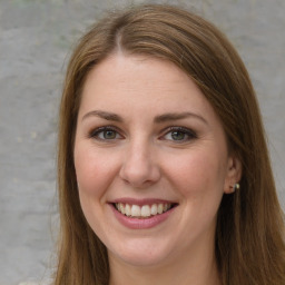 Joyful white young-adult female with long  brown hair and green eyes