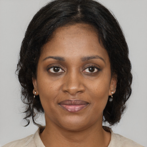 Joyful black young-adult female with long  brown hair and brown eyes