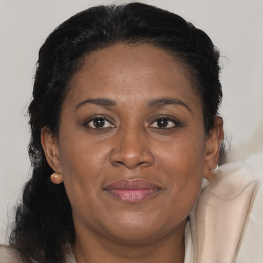 Joyful black adult female with long  brown hair and brown eyes