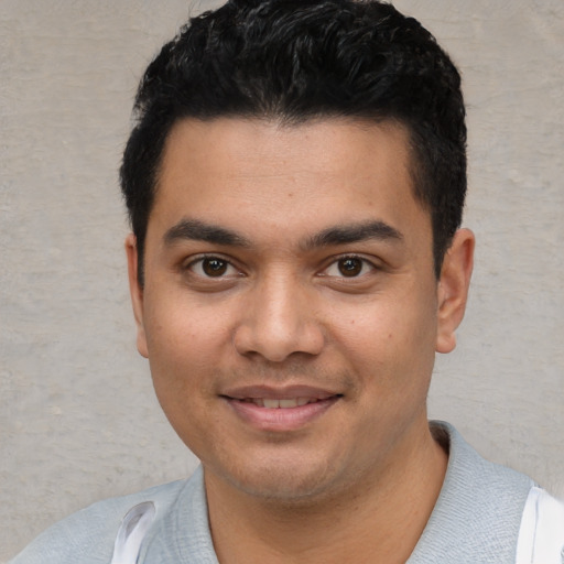 Joyful white young-adult male with short  black hair and brown eyes