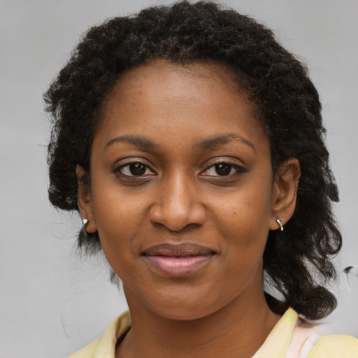 Joyful black adult female with medium  brown hair and brown eyes