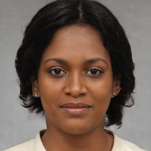 Joyful black young-adult female with medium  black hair and brown eyes