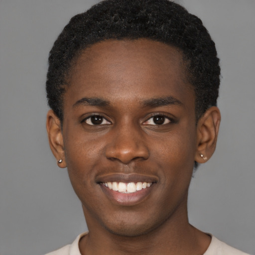 Joyful black young-adult male with short  brown hair and brown eyes