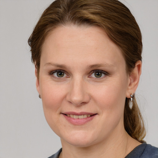 Joyful white adult female with medium  brown hair and grey eyes