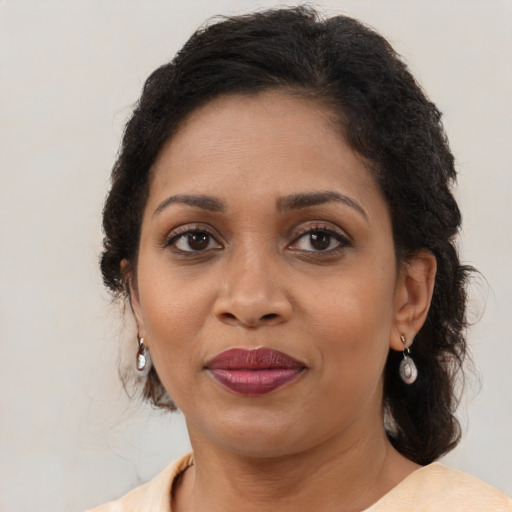 Joyful black adult female with medium  brown hair and brown eyes