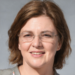 Joyful white adult female with medium  brown hair and blue eyes