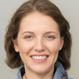 Joyful white adult female with medium  brown hair and grey eyes