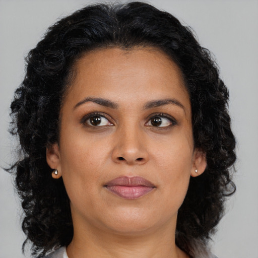 Joyful black young-adult female with long  brown hair and brown eyes