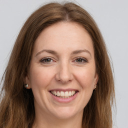 Joyful white young-adult female with long  brown hair and grey eyes