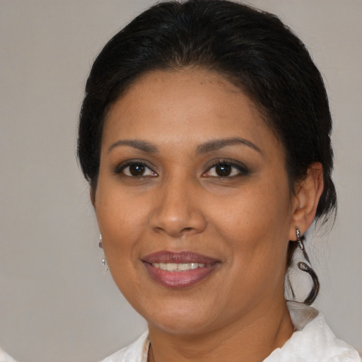 Joyful latino adult female with medium  brown hair and brown eyes